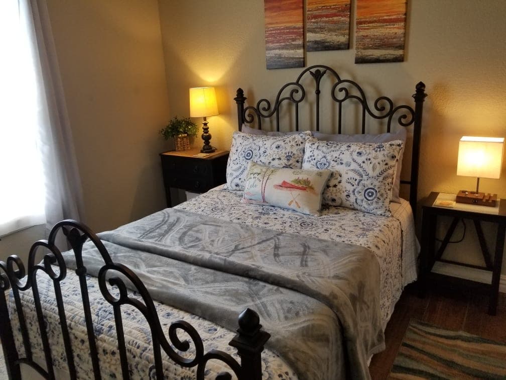 Queen bedroom with iron bed frame and bedside lamps