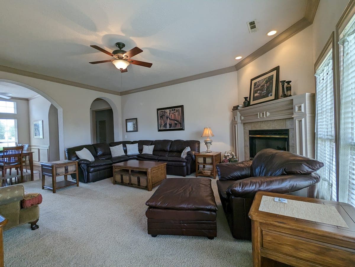 Spacious living room with leather sectional, fireplace, and large windows