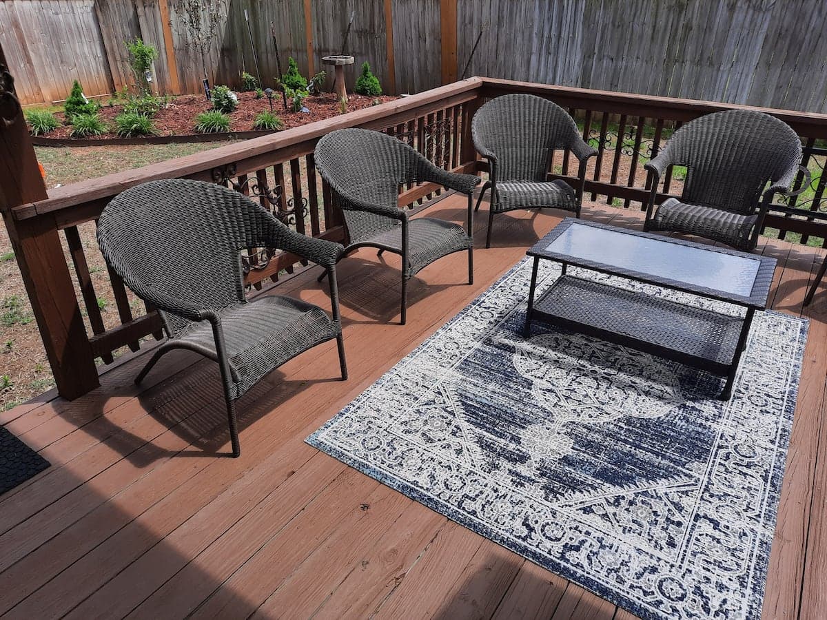 Large back deck with wicker seating and privacy fence