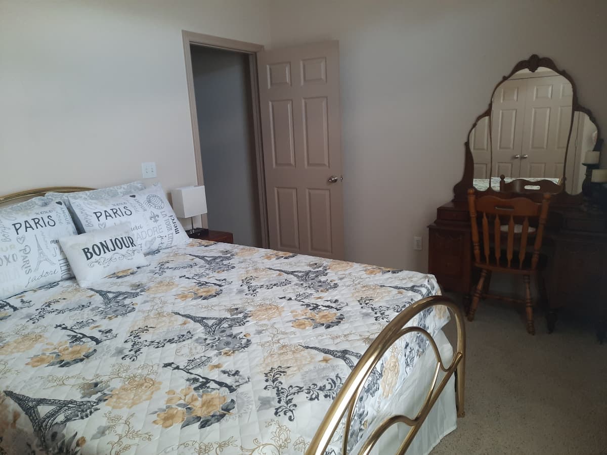 Queen bedroom with vanity and Paris-themed decor