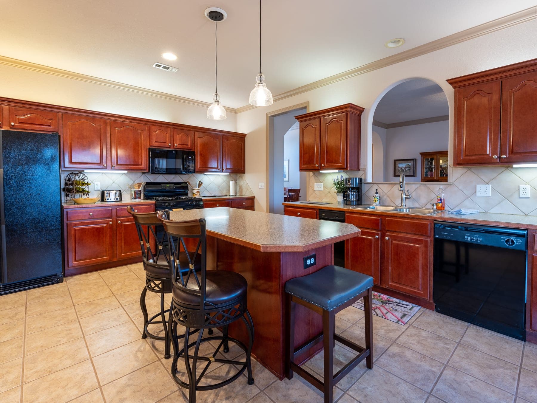 Large kitchen with island, bar stools, and plenty of counter space