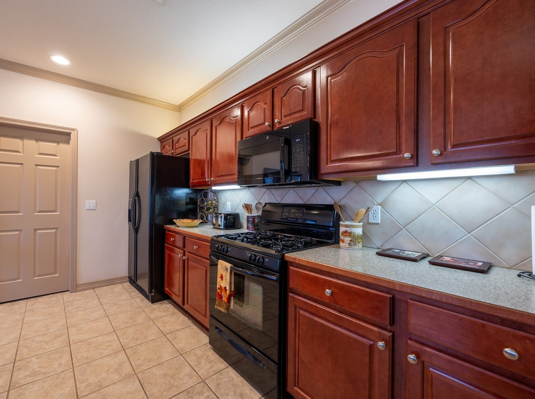 Kitchen with gas range and dark appliances
